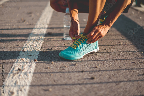 Female runner tying shoes