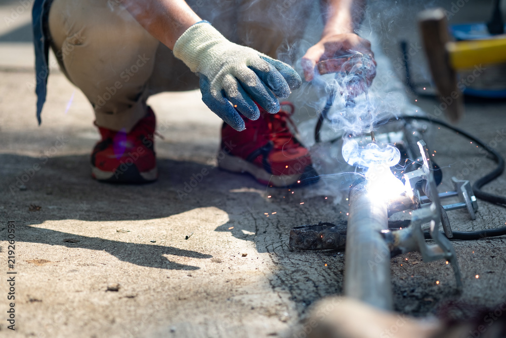 close up technician welding metal pole, dangerous worker. close up technician welding metal pole, dangerous worker.