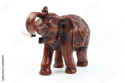 Brown elephant made of resin like wood carving with candle holder with white ivory. Stand on white background  Isolated  Art Model Thai Crafts  For decoration Like in the spa.