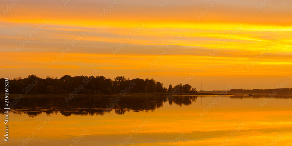 evening water landscape. beautiful orange sunset reflected in lake water