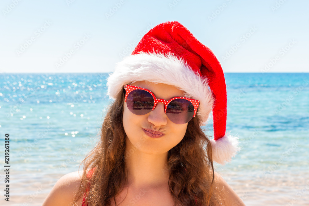 Christmas beach vacation travel portrait woman wearing Santa hat enjoying christmas on tropical beach Christmas beach vacation travel portrait woman wearing Santa hat enjoying christmas on tropical beach