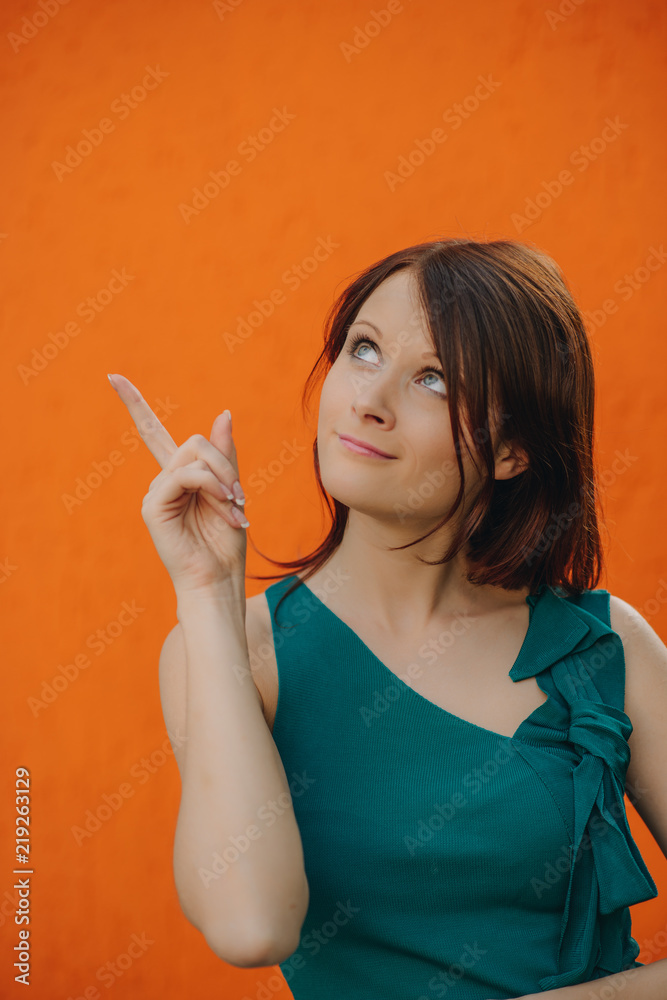 cheerfull beautiful young woman with red hair and blue eyes on orange background cheerfull beautiful young woman with red hair and blue eyes on orange background