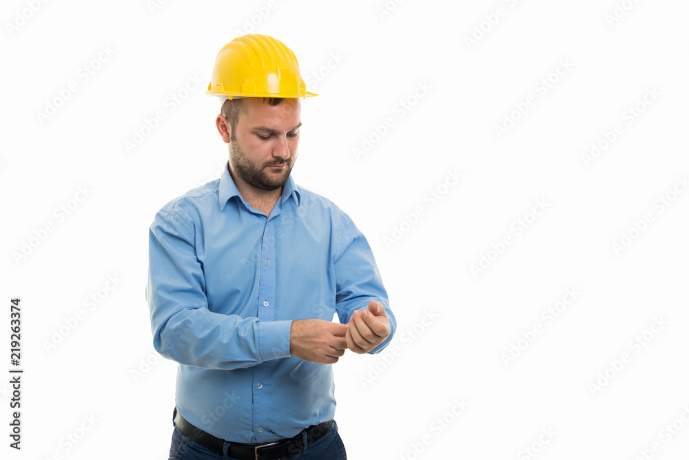 Young architect with yellow helmet arranging sleeve shirt Young architect with yellow helmet arranging sleeve shirt