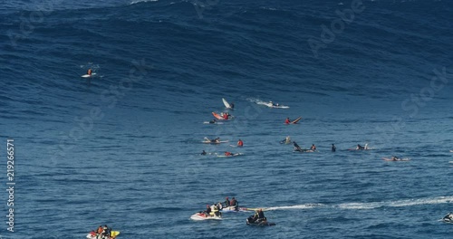 Surfers in front of breaking wave during big wave session on Maui coastline in Hawaii