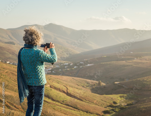 Woman on the hill taking a picture in Fuerteventura, Canary Islands, Spain.