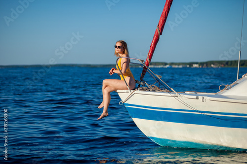 Girl sitting on the bow of the yacht, sailboat