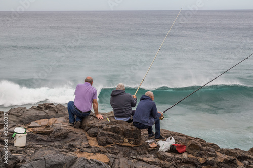 Men fishing on the rocks in Puertito de Los Molinos, Fuerteventura, Spain.
