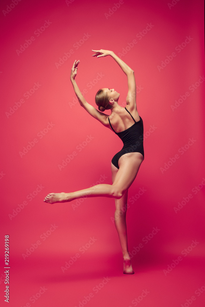 Young teen dancer on red studio background.