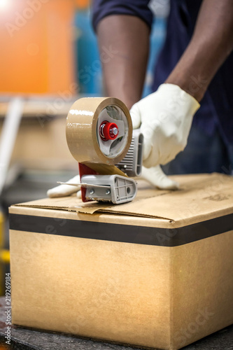 Box being taped shut in packaging plant.
