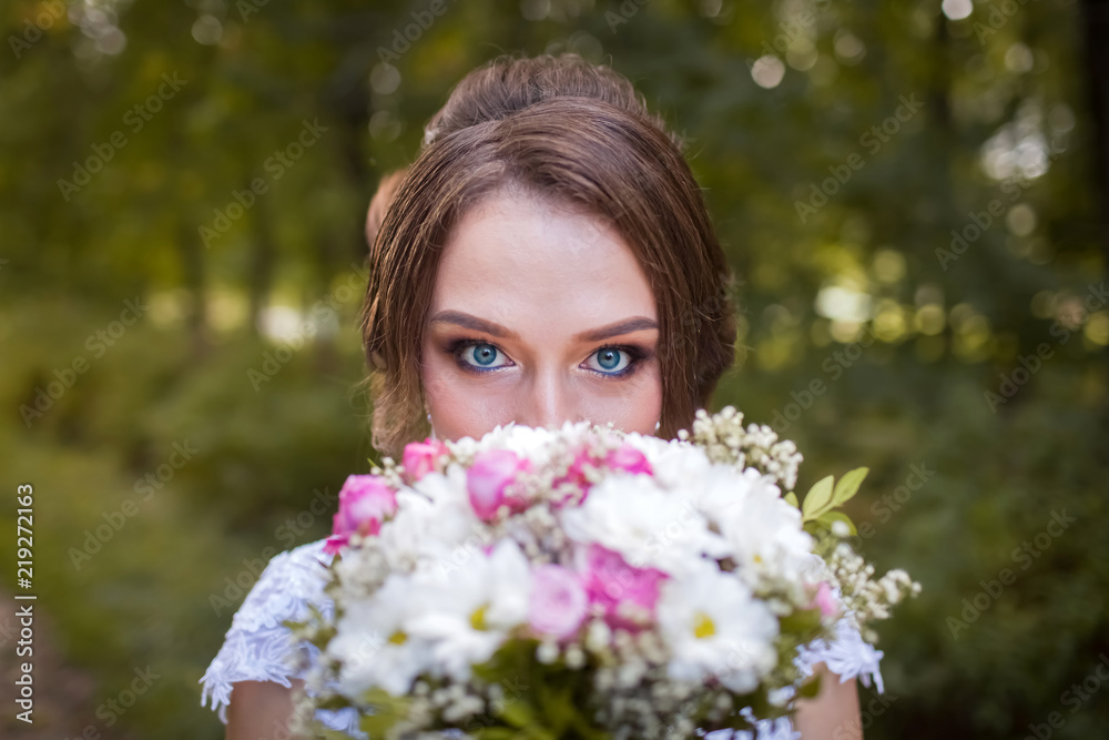 Beautiful bride with bridal bouquet. Portrait of a woman in white wedding dress in the autumn park Beautiful bride with bridal bouquet. Portrait of a woman in white wedding dress in the autumn park