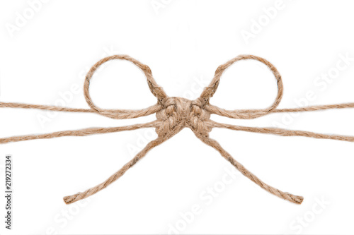 Natural brown jute twine hemp rope, tie a knot / bow in the middle of the cord. Isolated on white background. 