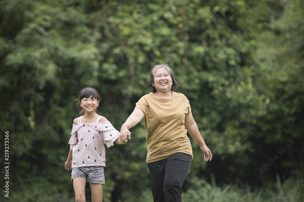 Grandmother Playing With Granddaughter Outdoors At The Park