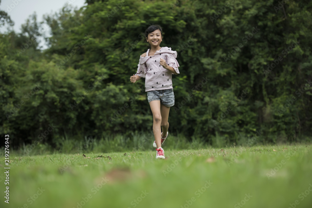 Happy cute little girl running on the grass in the park Happy cute little girl running on the grass in the park