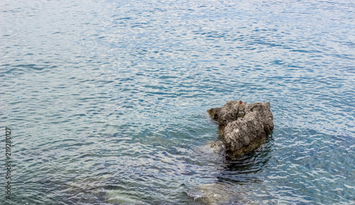 sea water surface with small waves and stone, copy space 