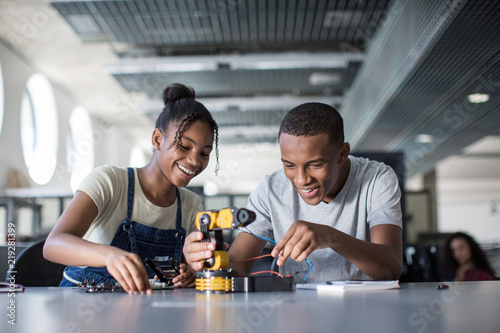 High school students working on a robotic arm in class photo