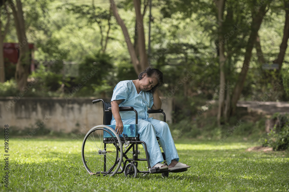 Lonely elderly woman sitting sad feeling on wheelchair at garden in hospital Lonely elderly woman sitting sad feeling on wheelchair at garden in hospital