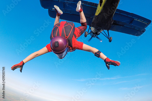 Skydiver in red jumping out of the plane