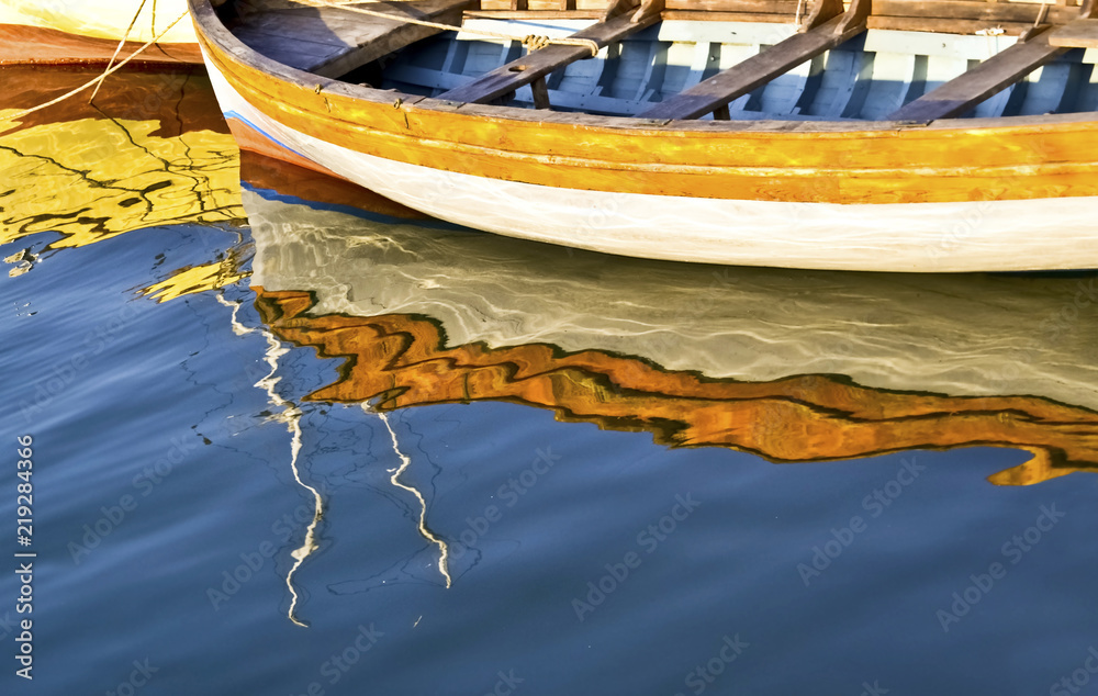 Obraz premium colorful water reflections of a fishing boat - Aegean sea Greece