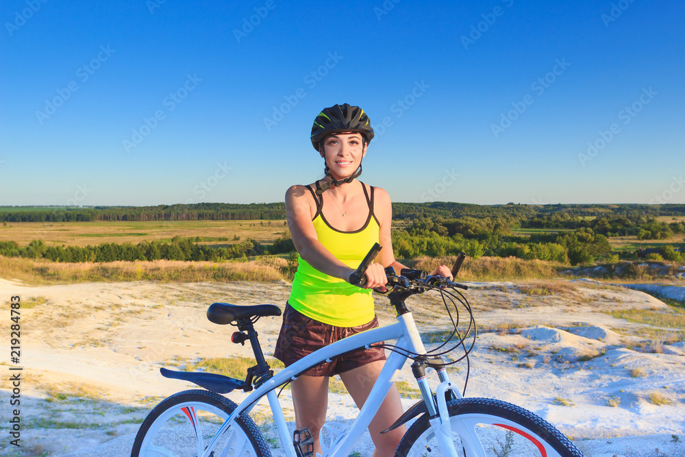 Fototapeta premium Young beautiful woman with a sport bike, soft focus background