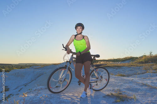 Young beautiful woman with a sport bike, soft focus background