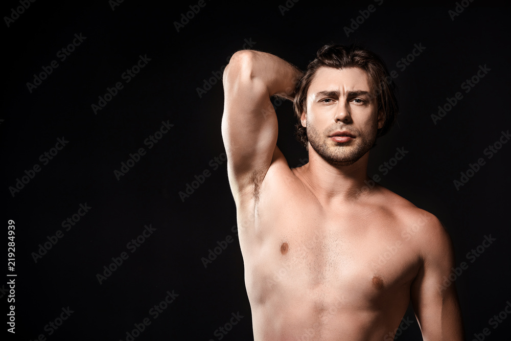 portrait of handsome shirtless man looking at camera isolated on black portrait of handsome shirtless man looking at camera isolated on black