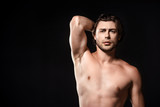 portrait of handsome shirtless man looking at camera isolated on black