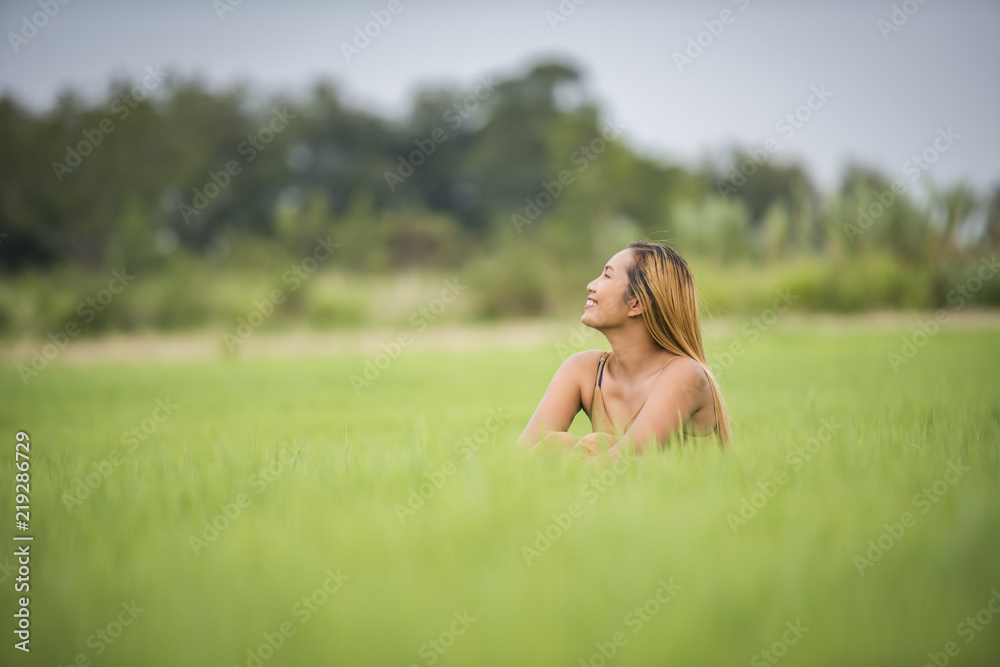 Young woman sitting feel good in grass field.