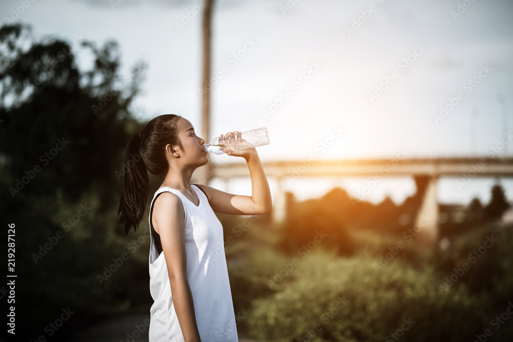 Beautiful young fitness woman drinking water after running exercise Beautiful young fitness woman drinking water after running exercise