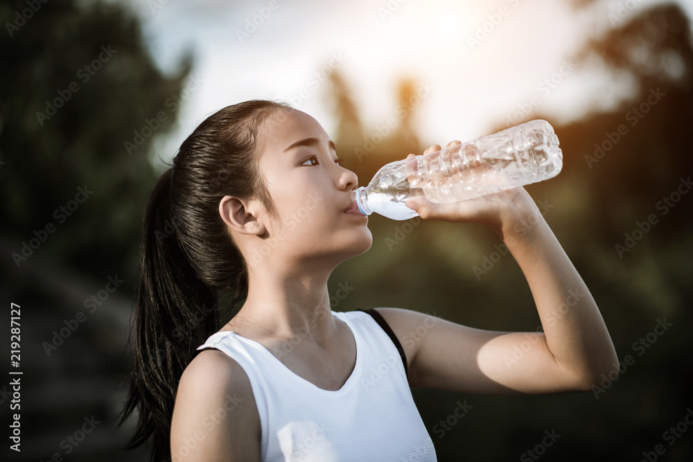 Beautiful young fitness woman drinking water after running exercise Beautiful young fitness woman drinking water after running exercise