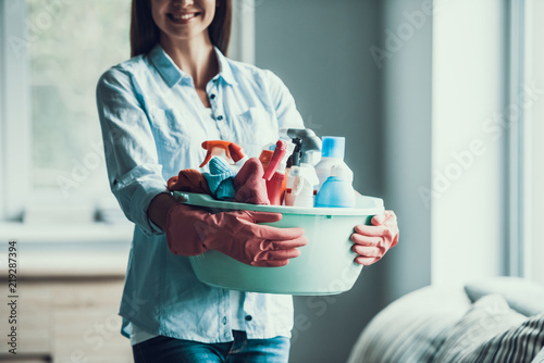 Young Happy Woman holds Cleaning Equipment at Home photo