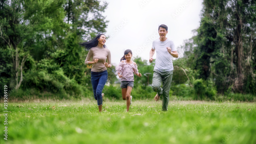 Happy family of three people, mother, father and child in green garden; Asian family are happy working in the parks;  Enjoying family time together in the meadow travel nature trip.