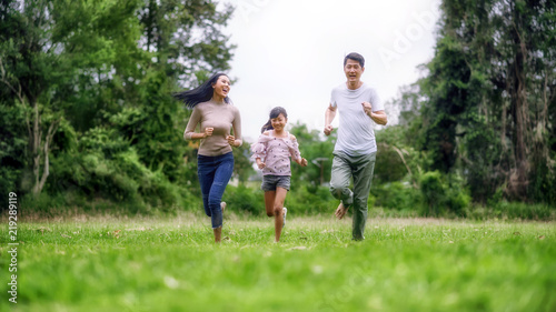 Happy family of three people, mother, father and child in green garden; Asian family are happy working in the parks; Enjoying family time together in the meadow travel nature trip.