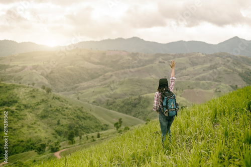 Asian young woman enjoy and stretching her arms with sky background in nature rice farm, her is feeling relax and happy in the meanwhile; Relax and happy concept.