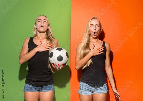 Fan sport women player holding soccer ball and sand singing national anthem isolated on studio background