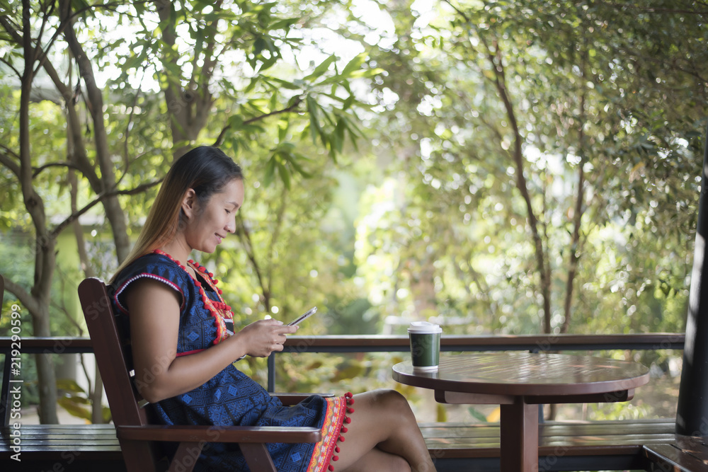 Naklejka premium Portrait of beautiful asian girl using her mobile phone in cafe.
