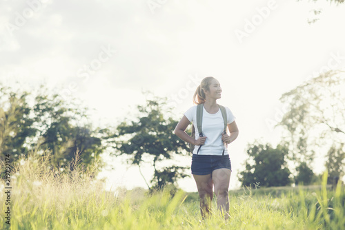 Hiking woman with backpack walking on a gravel road