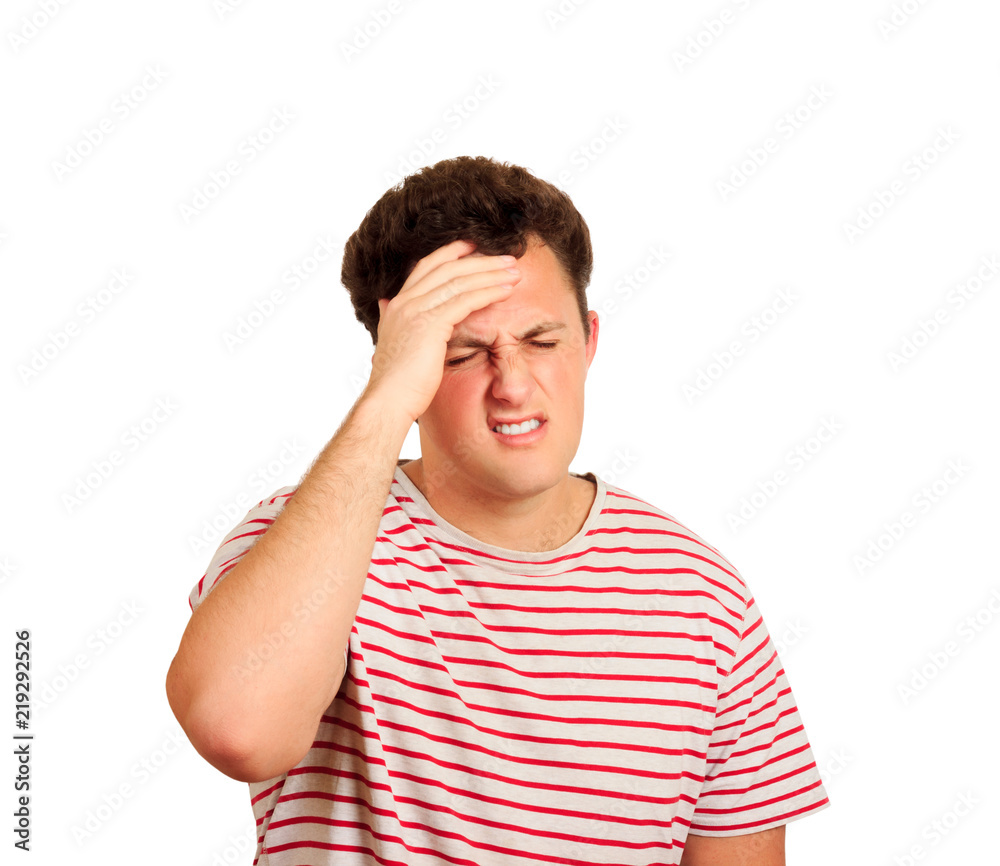 Tired unhappy guy holding hand on forehead, standing and suffers headache because of huge pressure at work . emotional man isolated on white background Tired unhappy guy holding hand on forehead, standing and suffers headache because of huge pressure at work . emotional man isolated on white background