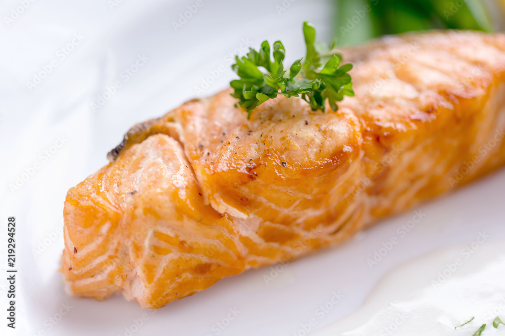 Salmon steak with white sauce on a white plate in the dining room Salmon steak with white sauce on a white plate in the dining room
