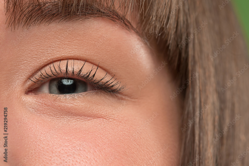 Fototapeta premium The close up gray eye on face of young beautiful caucasian girl