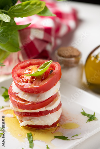 Caprese salad with italian mozzarella cheese on white plate photo