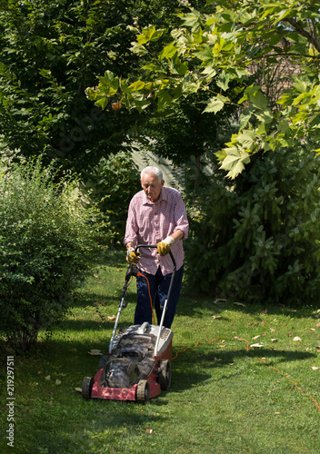 Old man mowing lawn