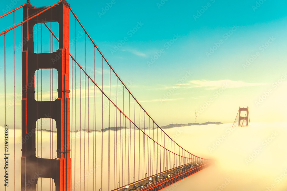 Fototapeta premium Overlook of the famous landmark the Golden Gate Bridge caught in the mist, San Francisco, California pacific coast, USA. Vintage look.