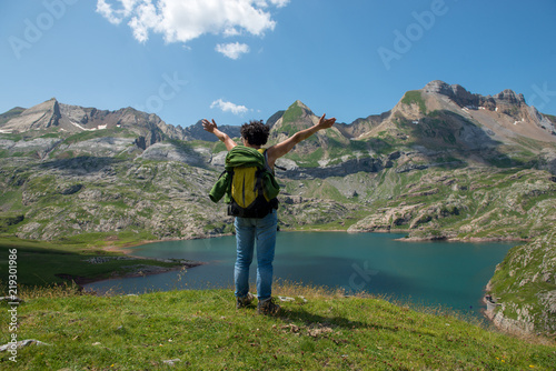 woman hiker looking at Lake Estaens in the Pyrenees mountains