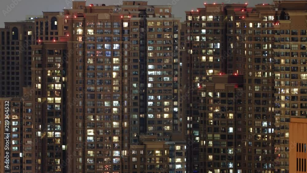 Time lapse of apartment building at night. Timelapse of residential flats windows lighting up and turning off overnight in Shanghai, China. Countless people live in massive building. Time lapse of apartment building at night. Timelapse of residential flats windows lighting up and turning off overnight in Shanghai, China. Countless people live in massive building.