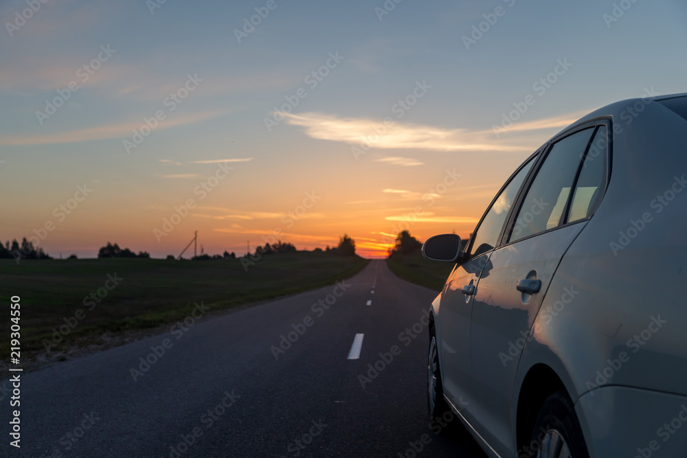Car driving towards the sunrise