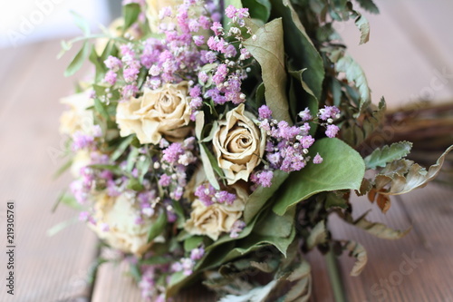 Getrockneter Blumenstrauß mit weisen Rosen und lila Blümchen