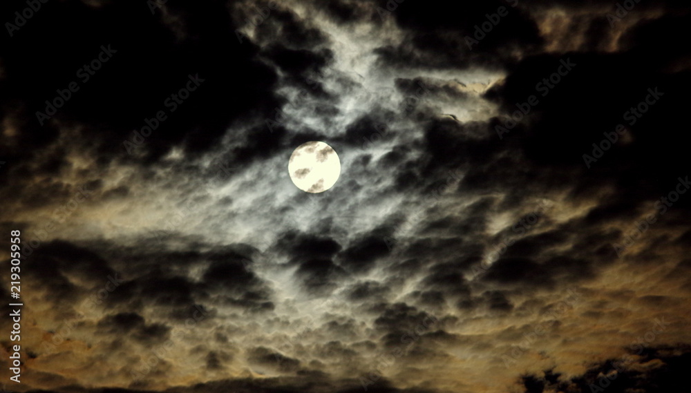 Naklejka premium Księżyc na tle ciemnego, nocnego, lekko zachmurzonego nieba