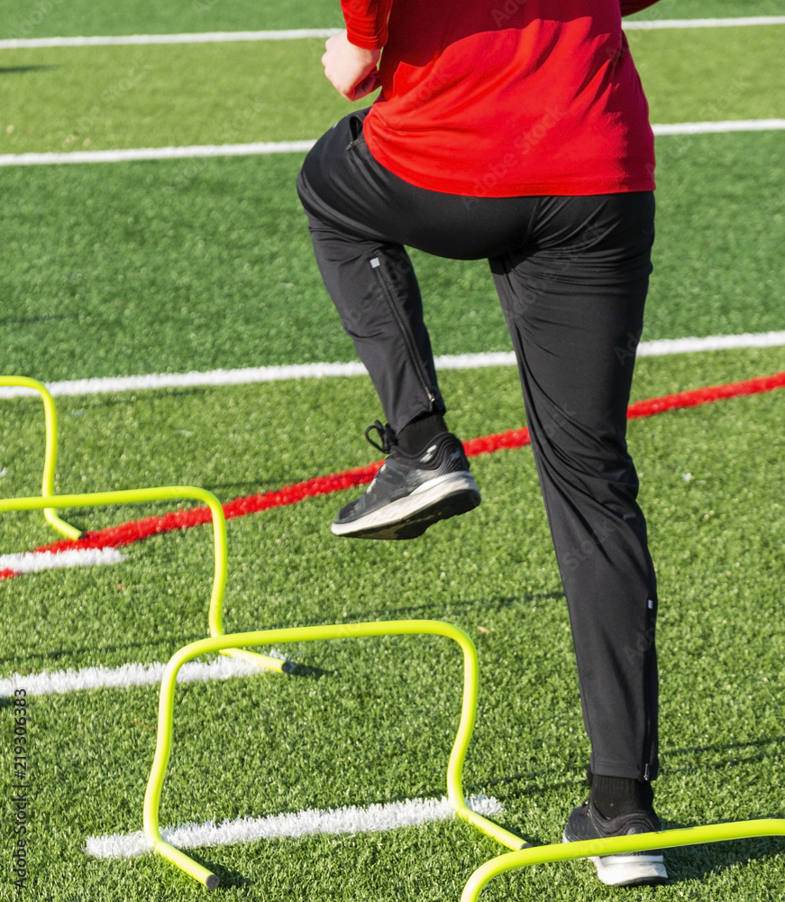 Obraz premium Runner stepping over yellow banana hurdles