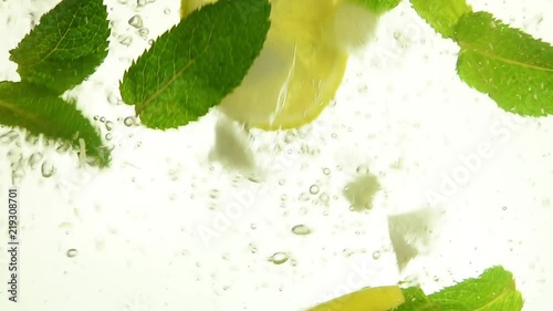 Close up ice cubes, mint leaves, lemon in mojito
