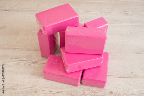A stack of bricks for yoga pink color close-up. A stack of blocks for Pilates rose on a light background. Monophonic blocks for stretching